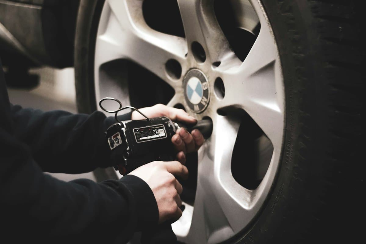 Technician fitting a wheel with a torque tool